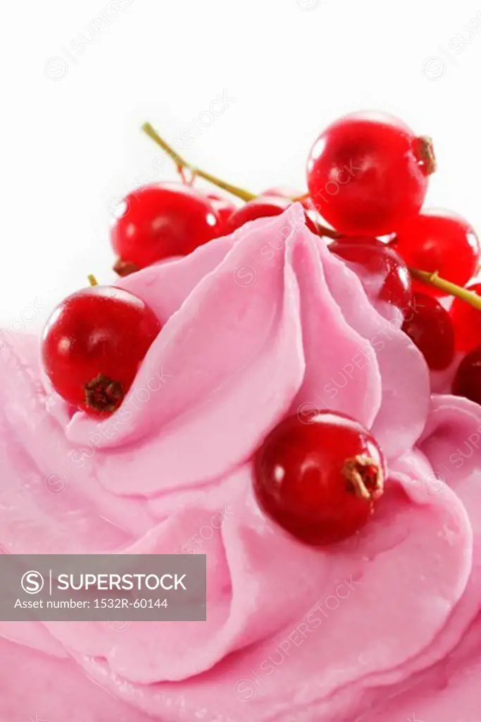 Redcurrant yogurt ice cream garnished with fresh redcurrants (close-up)