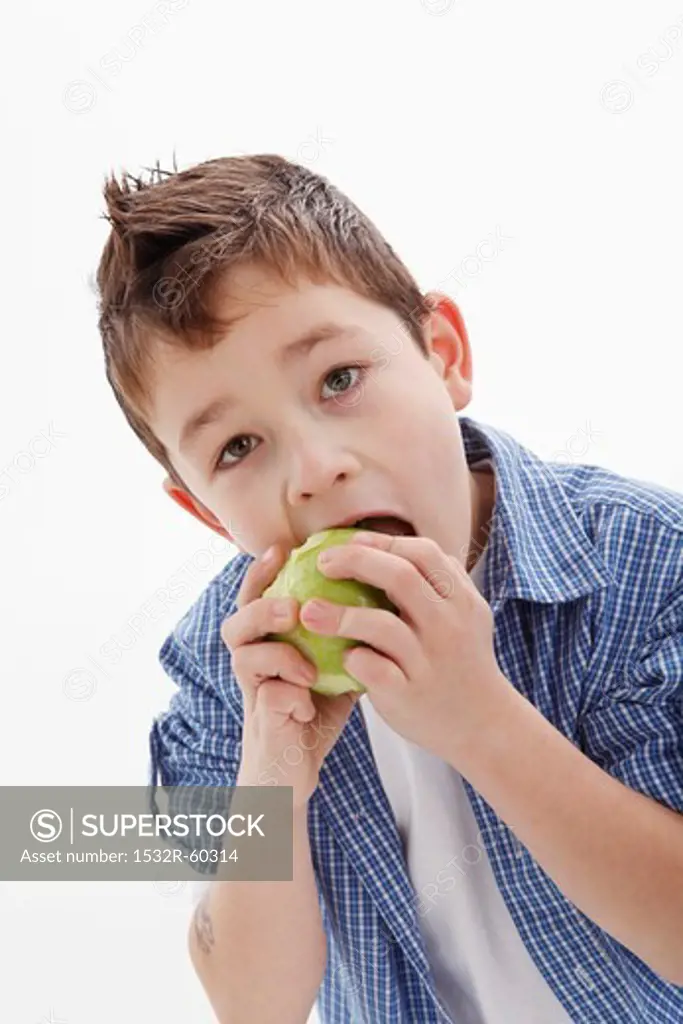 A little boy eating an apple