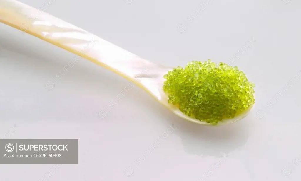 Green Masago caviar (roe from a flying fish) on a mother of pearl spoon
