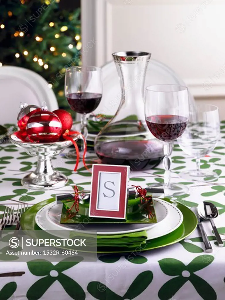 A table laid in green and white for Christmas with red wine