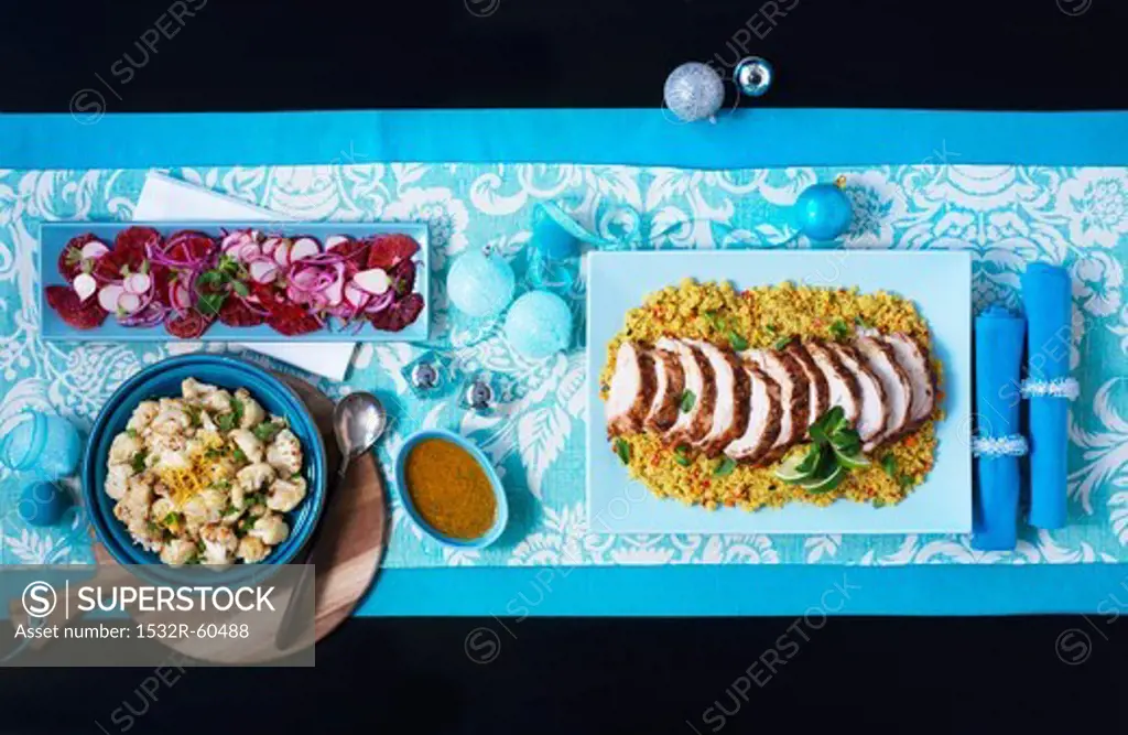Maroccan roast turkey in slices on couscous with cauliflower and salad (viewed from above)