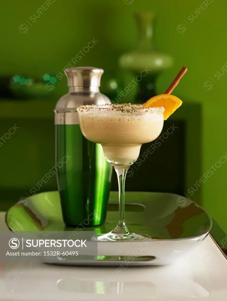 Frozen martini in a glass with sugar on the rim of the glass and a shaker