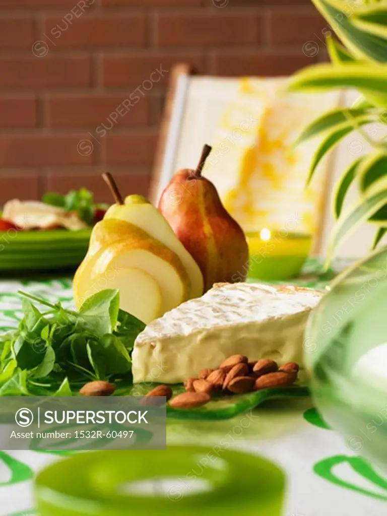 Cheese platter with brie, almonds, baby spinach and pears