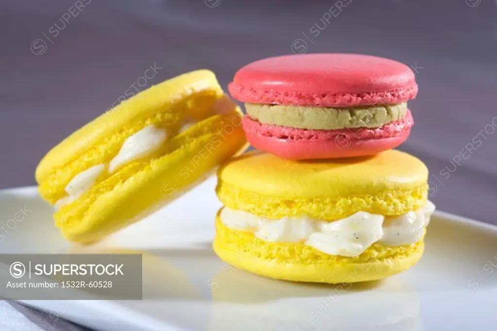 Yellow macaroons with vanilla cream, pink macaroon with pistachio cream