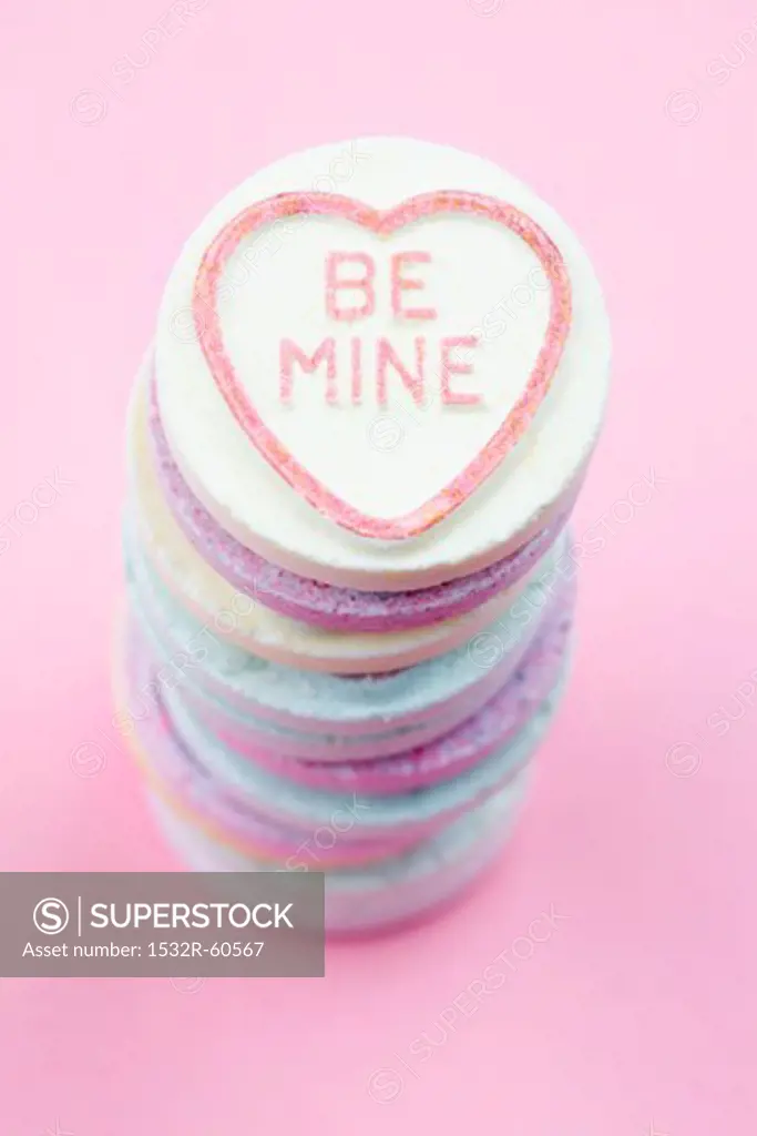 Stacked brightly colored candies with 'Be Mine' written on them
