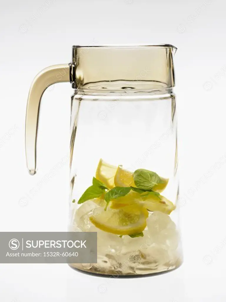 Glass carafe with lemons, mint and ice cubes