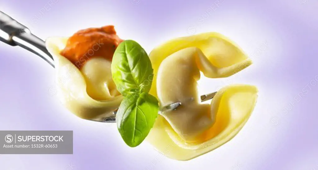 Tortellini with tomato sauce on a fork