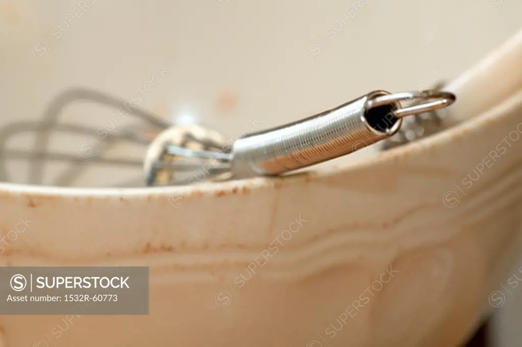 A whisk in a ceramic bowl