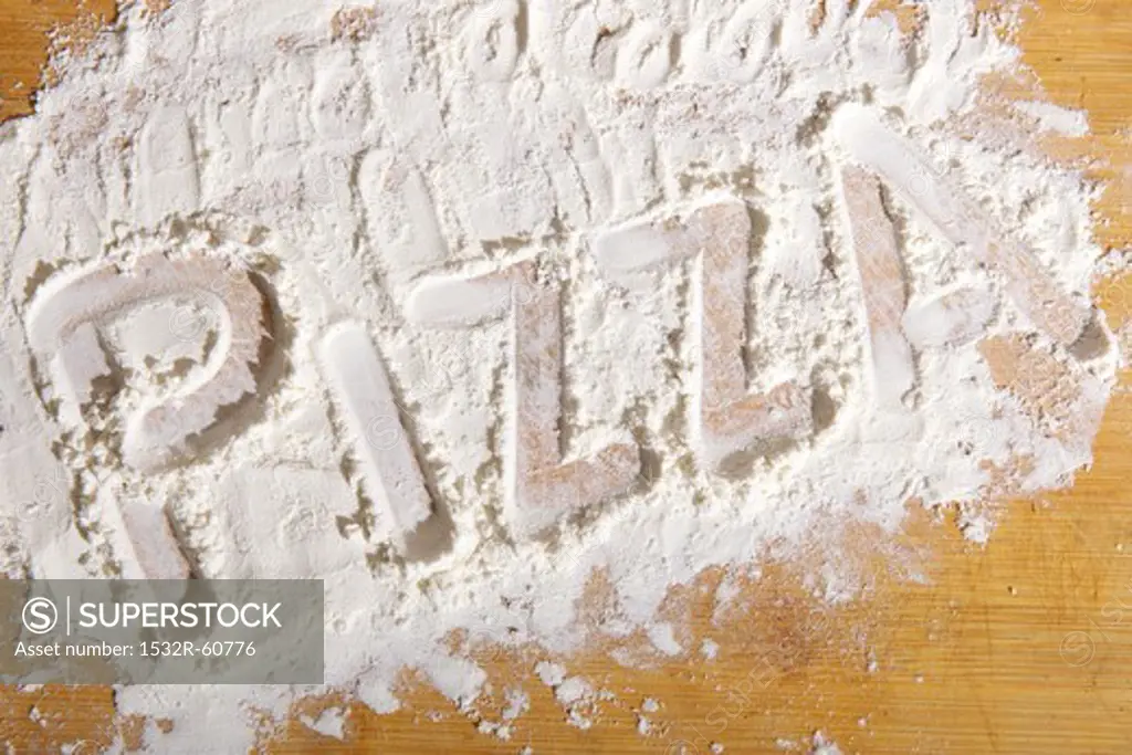 The word 'pizza' written in flour