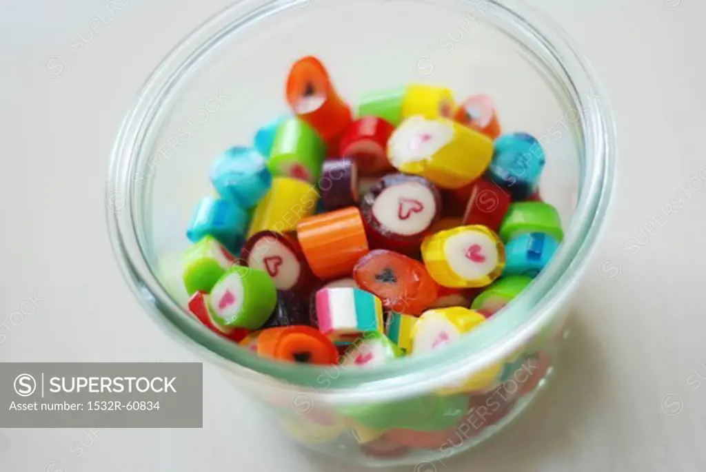 Brightly colored hard candy (with hearts in the center) in a glass