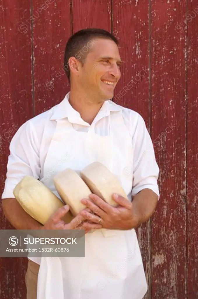 Cheese Maker in Apron Holding Goat Cheese Rounds