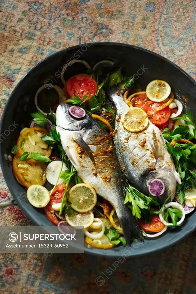 Dorade Fish Cooked in a Skillet with Tomatoes, Lemons and Parsley