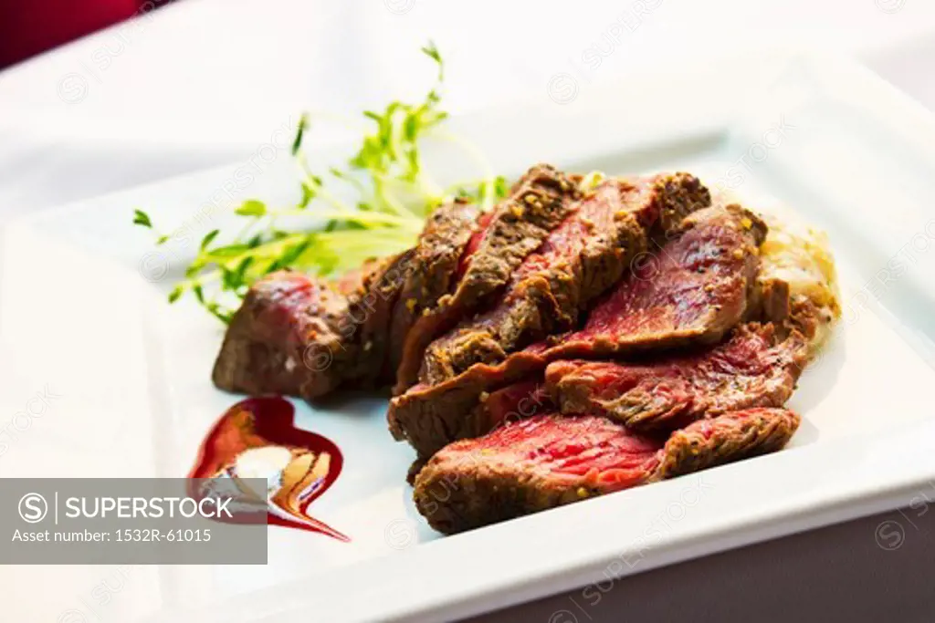 Sliced Beef Tenderloin with Potatoes on a White Plate