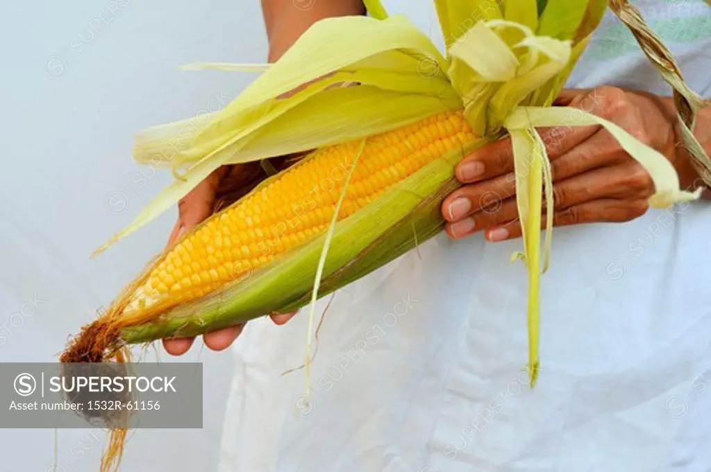 A woman holding a corn cob