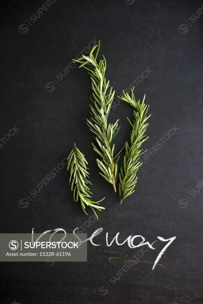 Fresh Rosemary Sprigs on a Chalk Board with the Word ""Rosemary"" Written in Chalk