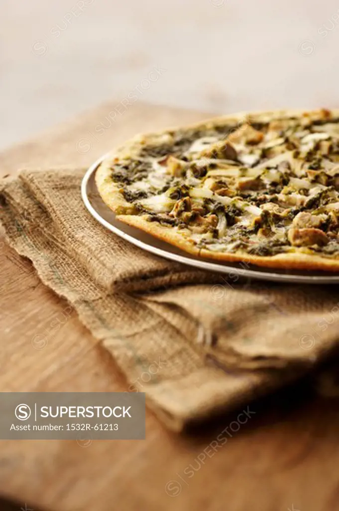 Thin Crust Pizza Topped with Chicken, Mushrooms, Onions and Pesto