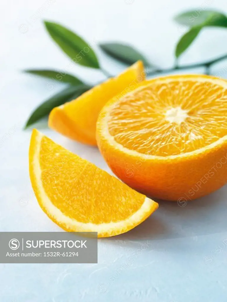 Half an orange and an orange slice with leaves