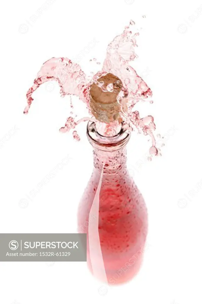 Rose wine spraying out of a bottle