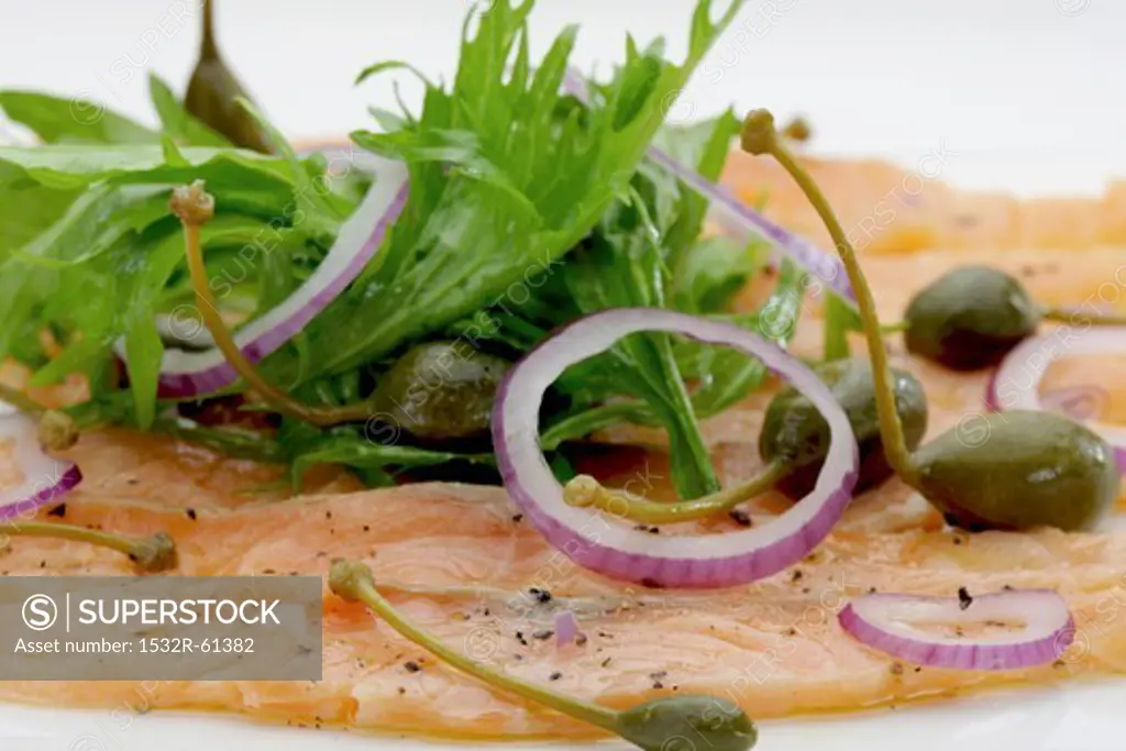 Salmon carpaccio with rocket, onions and capers