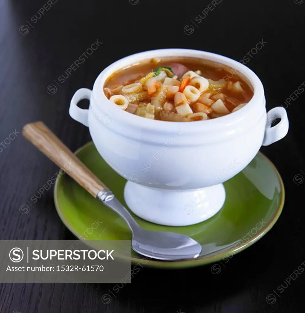 Bowl of Minestrone Soup on a Green Plate with Spoon