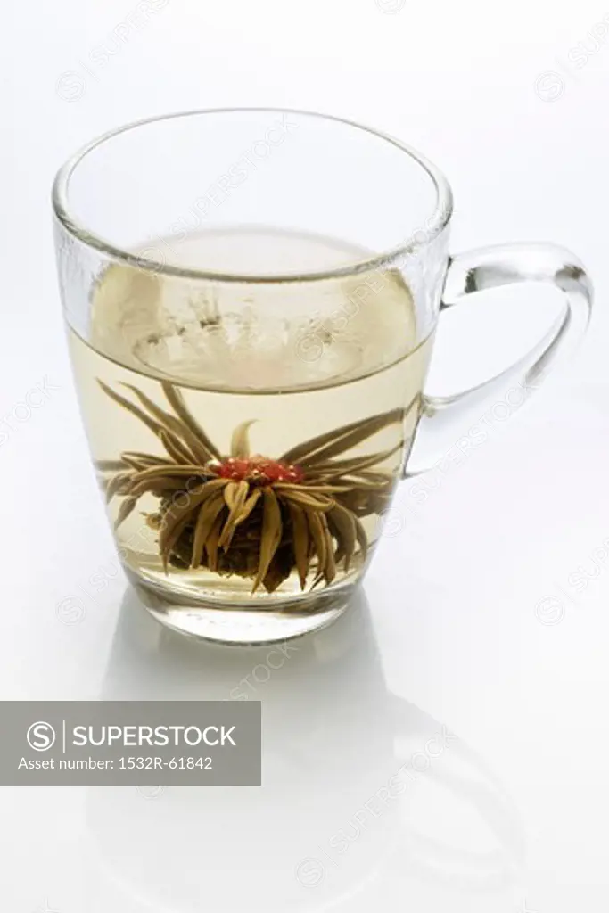 A glass of jasmine tea with a tea rose