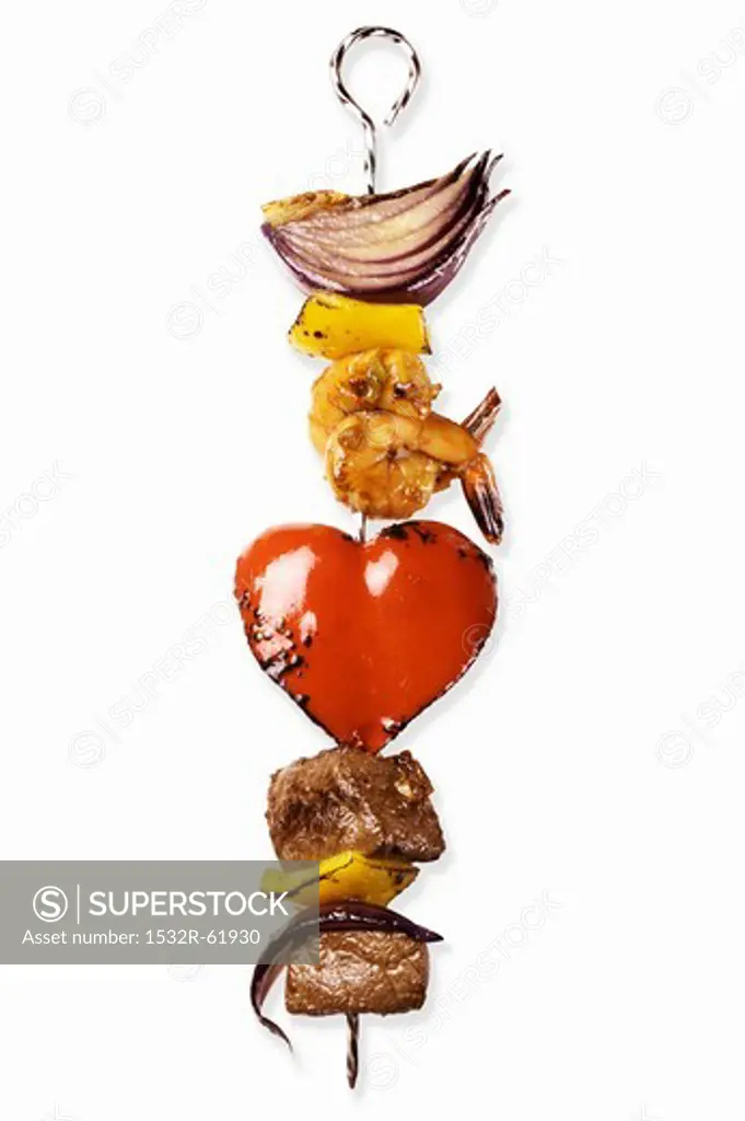 A kebab with meat, prawns, onions and a heart-shaped piece of pepper
