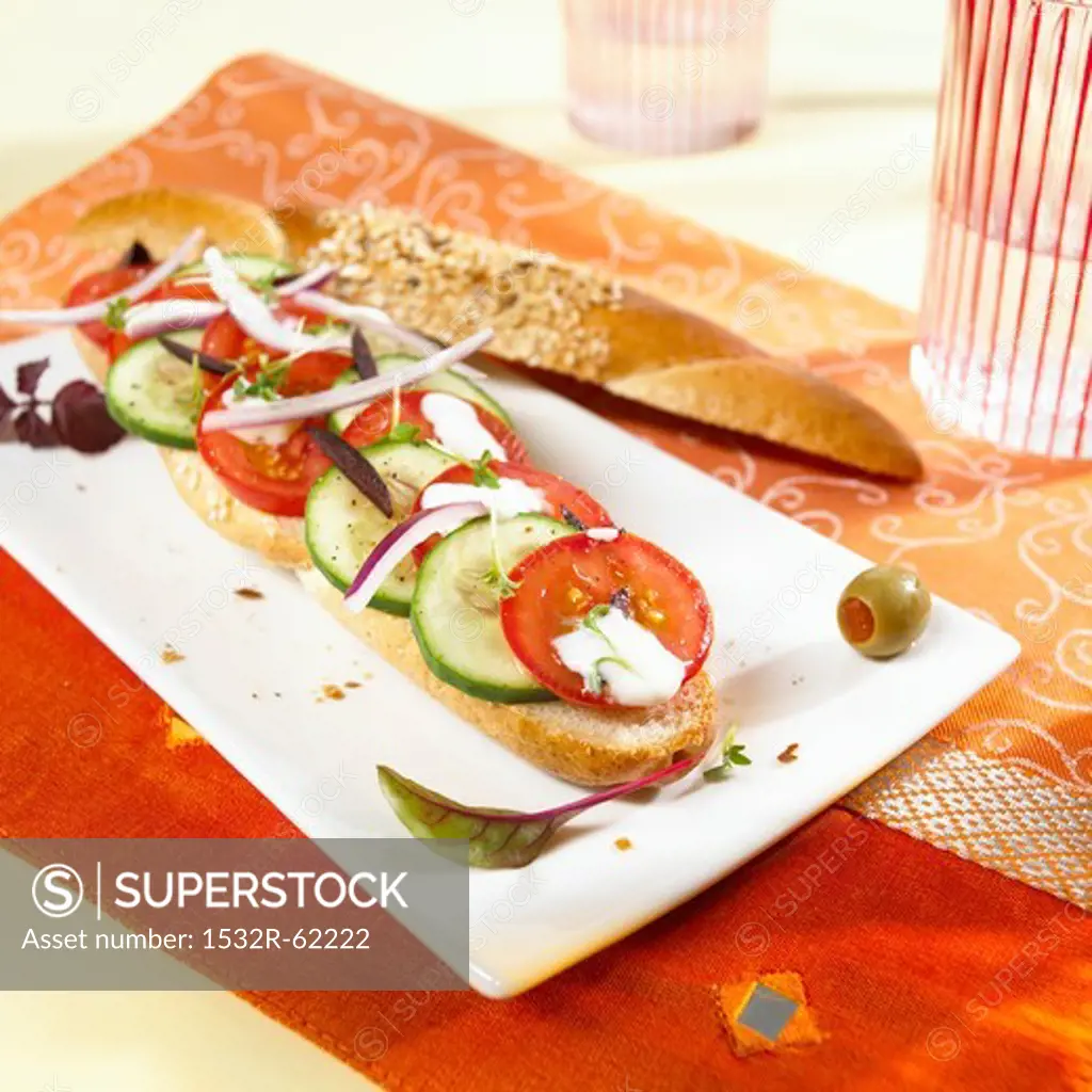 A grain baguette topped with Greek salad