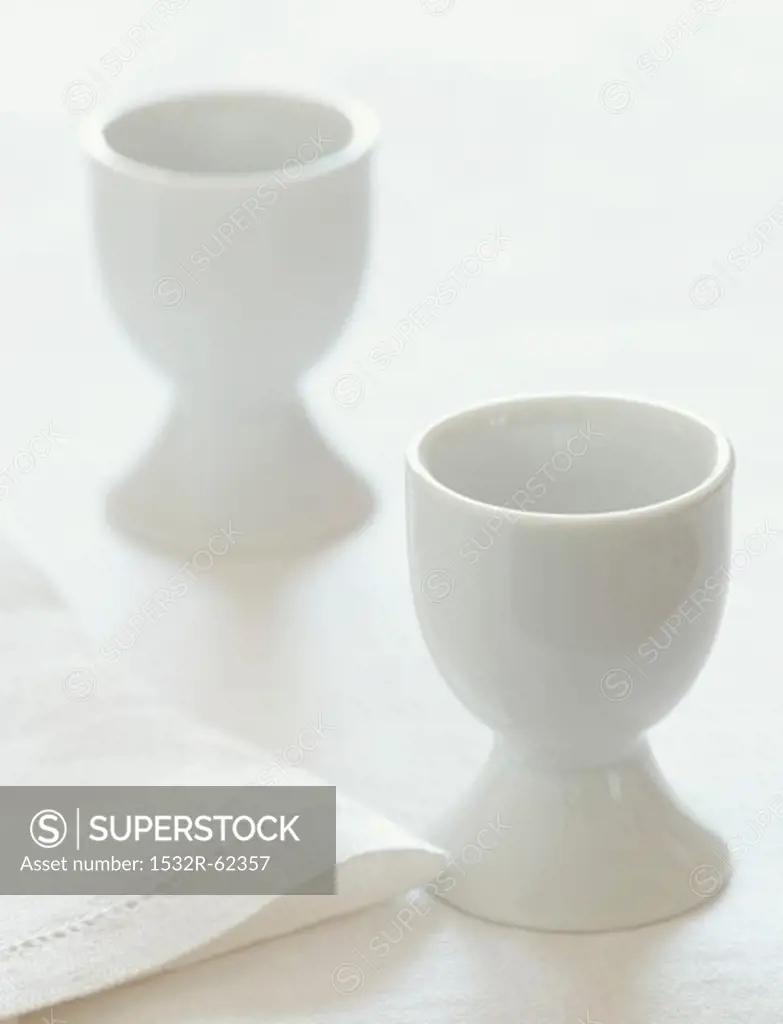 Two White Egg Cups with a White Napkin