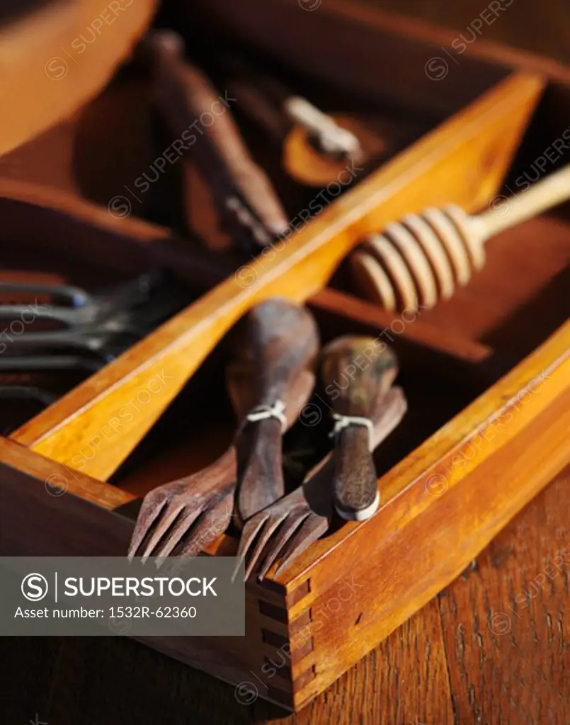 Old Wooden Spoons and Forks with Old Tools in a Wooden Box