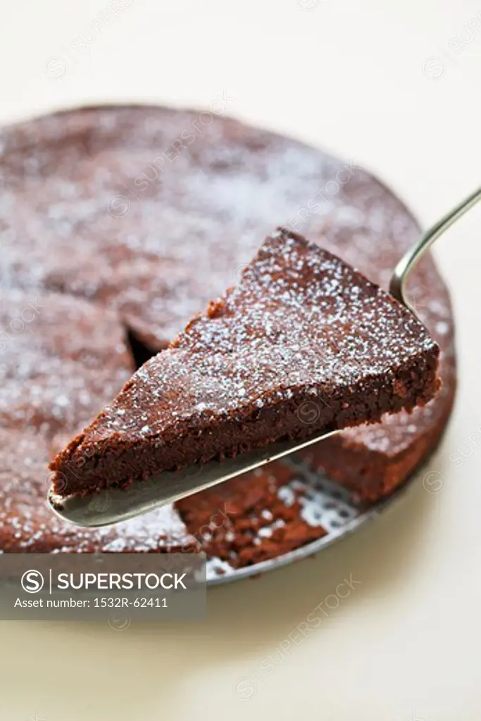 A chocolate cake with a piece on a cake slice