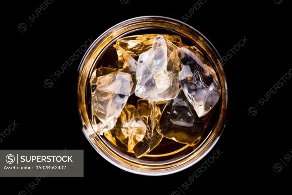 A glass of whiskey with ice cubes (seen from above)