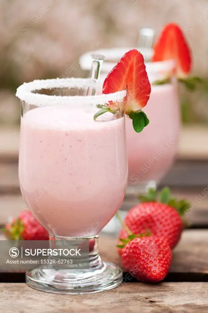 Strawberry smoothie in glasses with a sugared rim