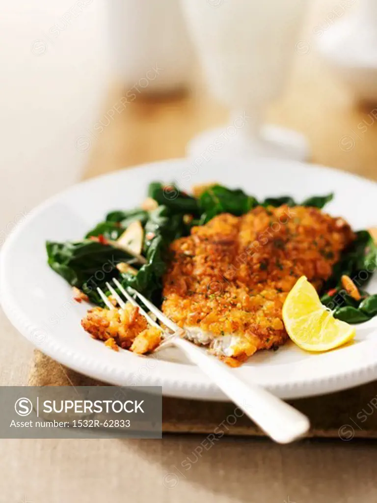 A breaded fish fillet with spinach
