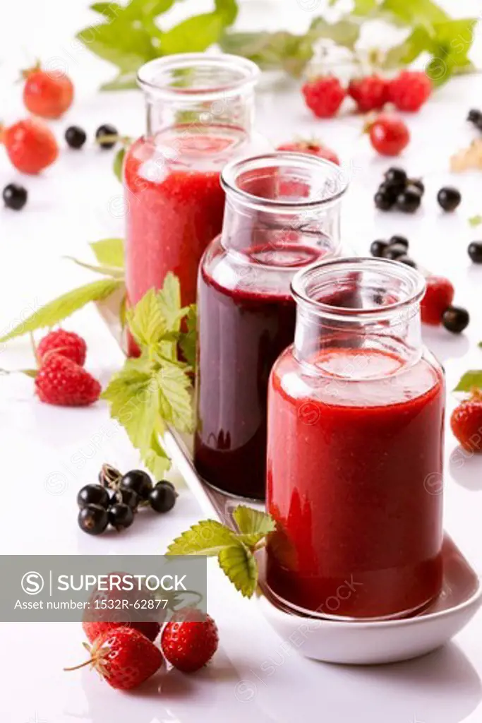 A raspberry smoothie, a redcurrant smoothie and a strawberry smoothie