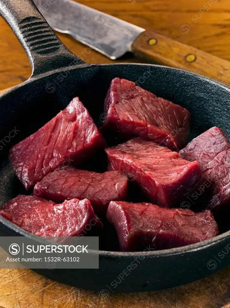 Cubed venison in frying pan