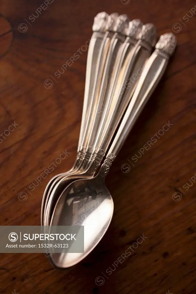 Silver Spoons on a Wooden Table; From Above