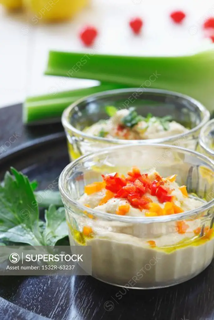 Bowl of Hummus with Chopped Red Peppers; Celery Sticks