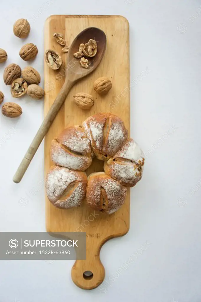 Walnut bread on a chopping board with a wooden spoon