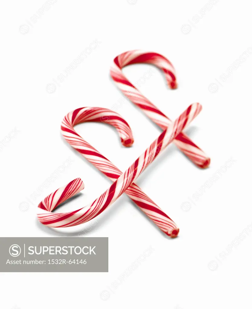 Three Red and White Striped Candy Canes on a White Background