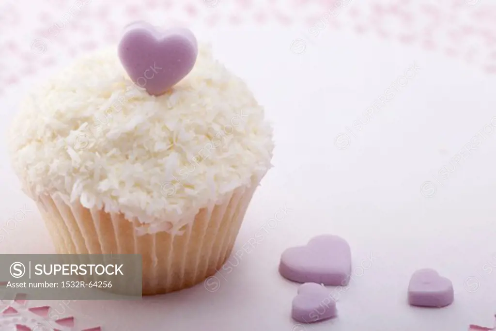 Cupcake with grated coconut and sugar heart