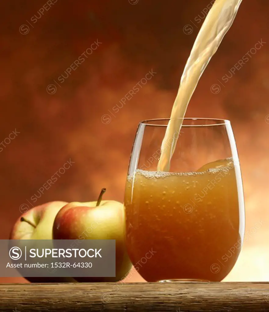 Pouring 'naturally cloudy' apple juice into a glass