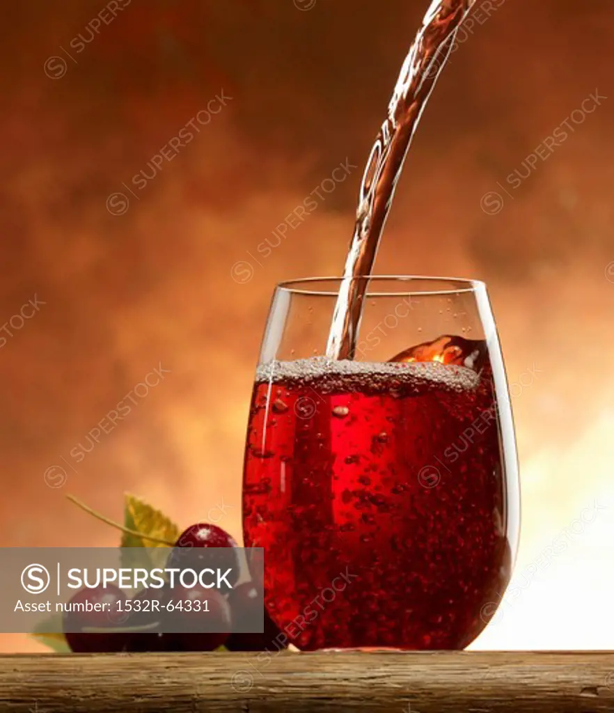 Pouring cherry juice into a glass