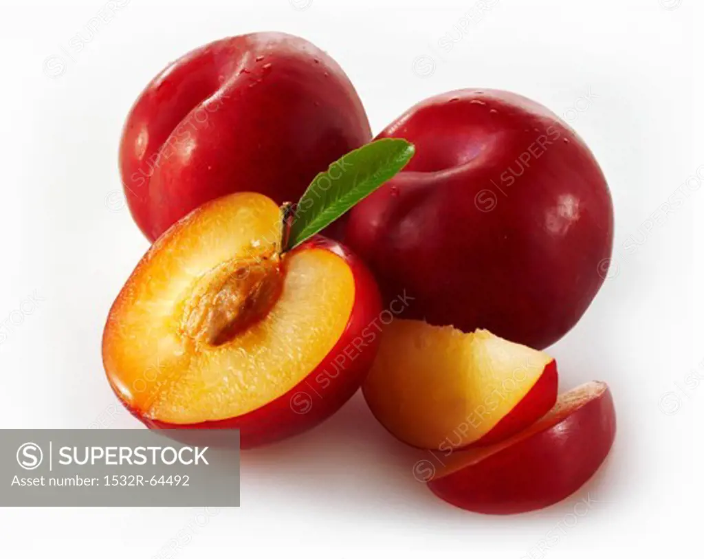 Whole red plums, halved plums and plum slices