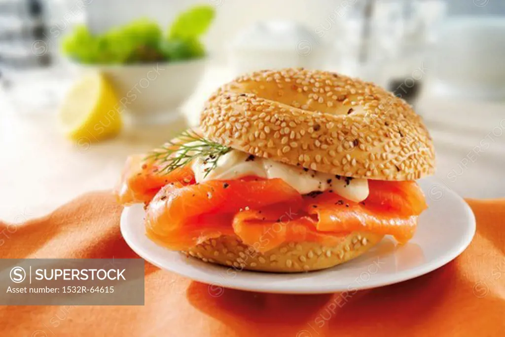 A sesame bagel with smoked salmon and mayonnaise