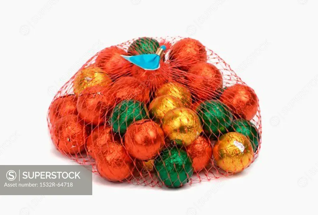 Chocolate balls, wrapped in foil, in a mesh bag