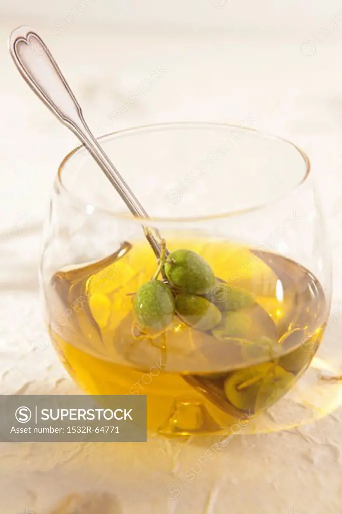 Glass with olives and olive oil