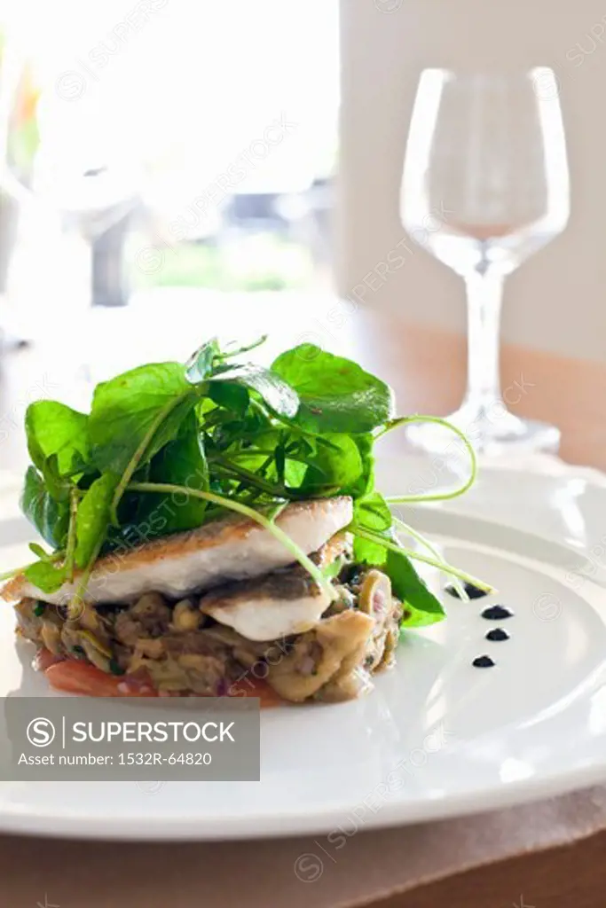 Sea bass on a bed of vegetables with water cress