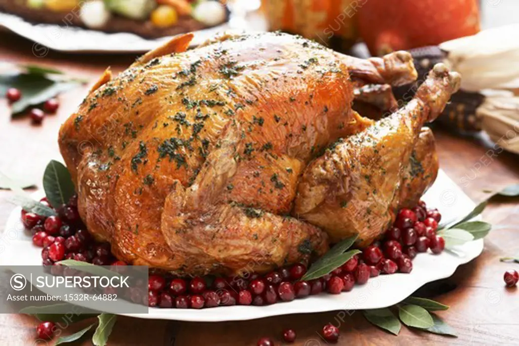 Whole Roast Turkey on a Platter with Cranberries and Bay Leaves