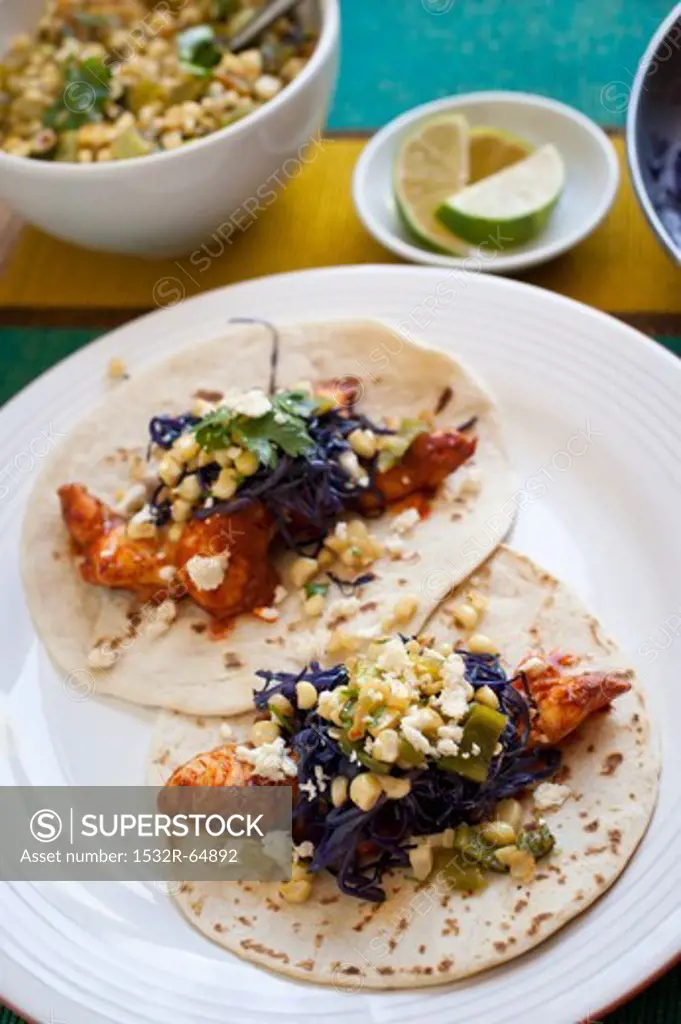 Two Catfish Tacos Topped with Braised Purple Cabbage, Corn and Chili Salsa and Cotija Cheese