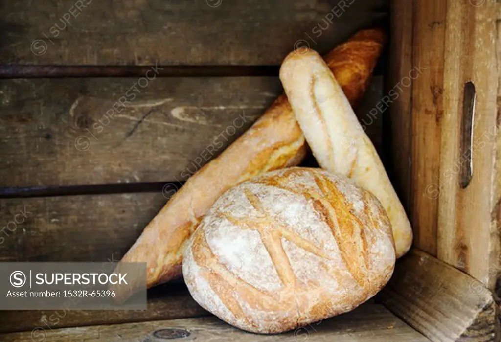 Boule, Ficelle und Baguette (French white bread) in a wooden crate